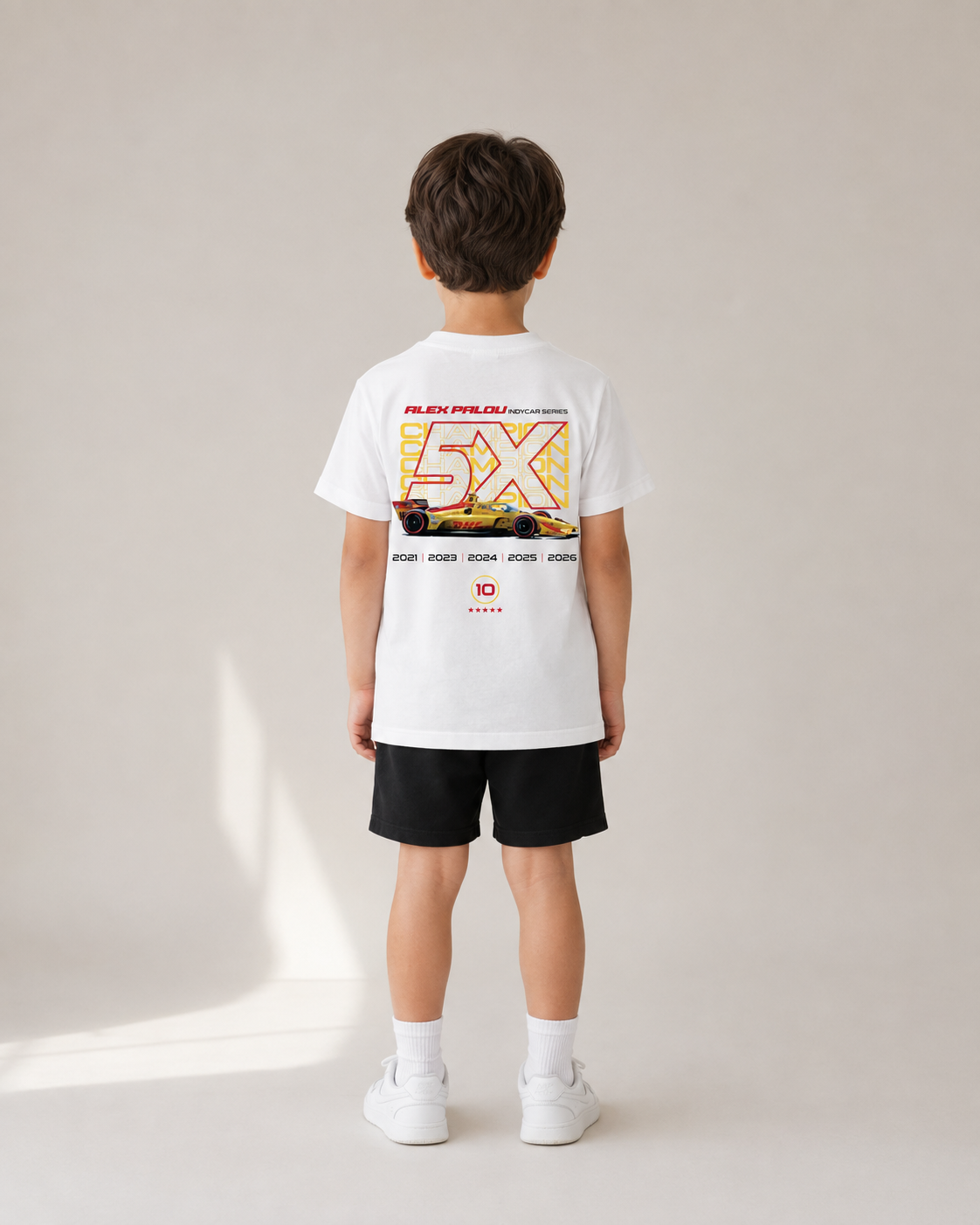 Child wearing the KIDS Champion Tee, back view — studio mockup